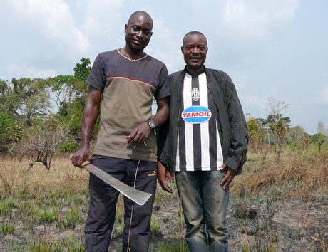 Community members Serge Etele, at left, and Viany Abia at the community's farm in Cameroon. (Photo by Nama Naser)