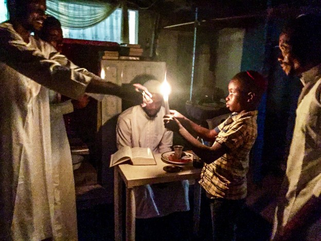 Young boy lighting the candle during havdalah